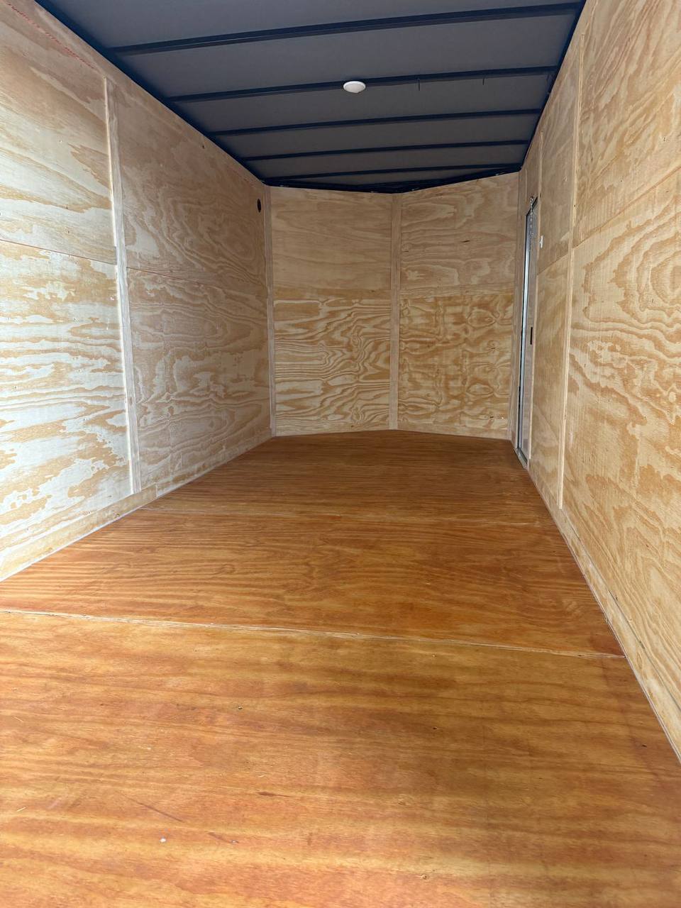 Plywood interior floor and walls inside enclosed trailer